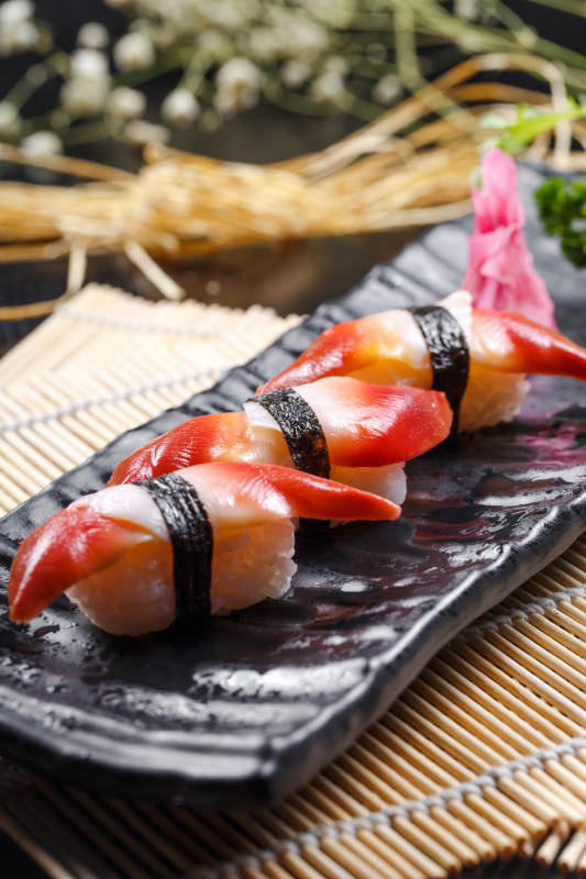 北极贝手握寿司摆放在寿司帘上