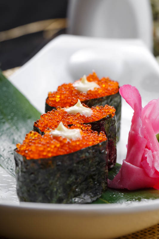 鹅颈瓷盘装的蟹子军舰手握寿司摆放在石头上