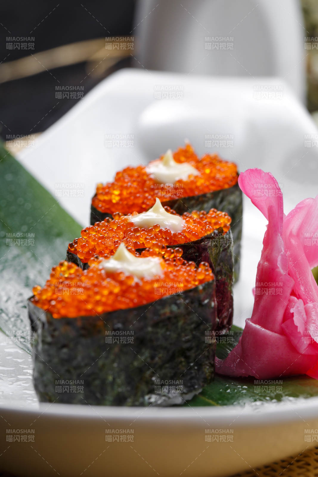 鹅颈瓷盘装的蟹子军舰手握寿司摆放在石头上