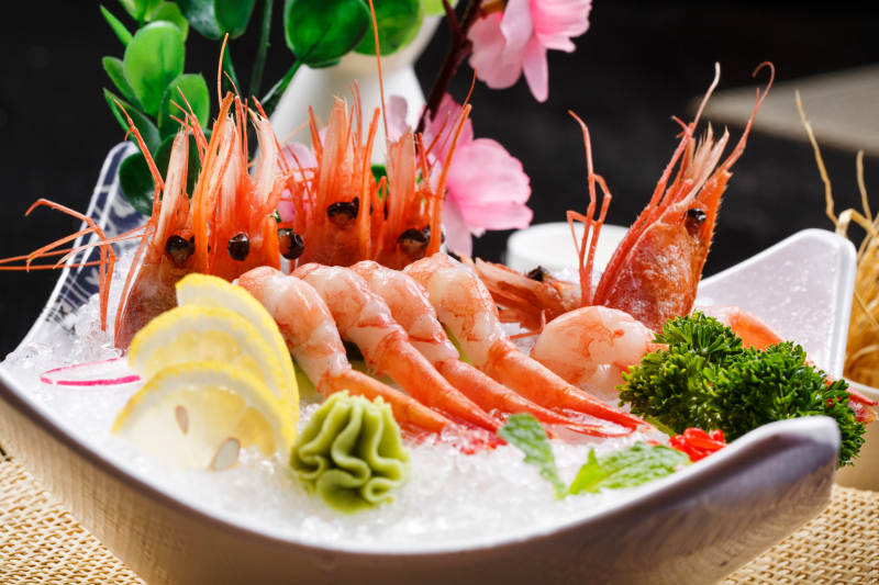 北极甜虾刺身摆放在草垫上