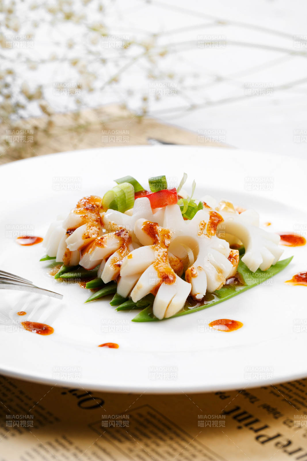 日式铁板煎鱿鱼卷摆放在英文包装纸上