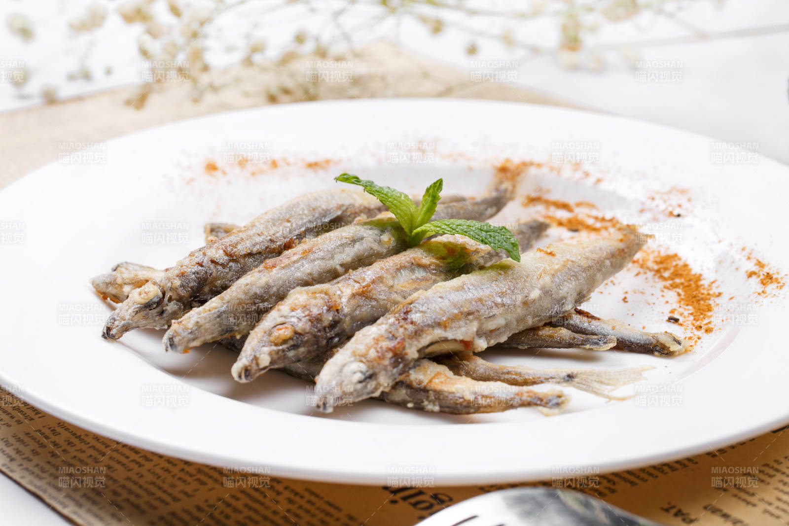 日式鐵板煎椒鹽多春魚擺放在英文包裝紙上