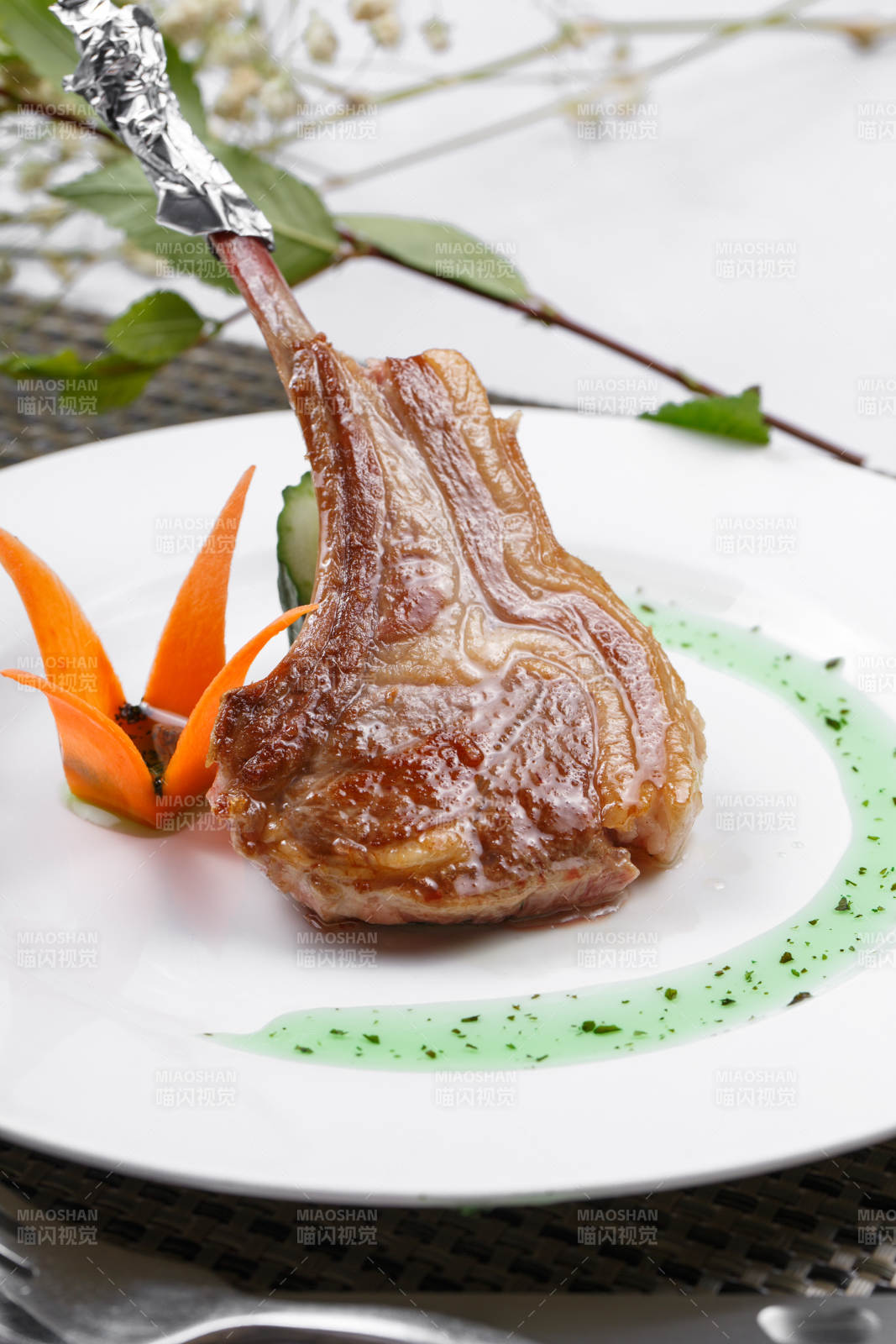 圆形白瓷盘装的波尔多法式铁板羊排摆放在餐垫上