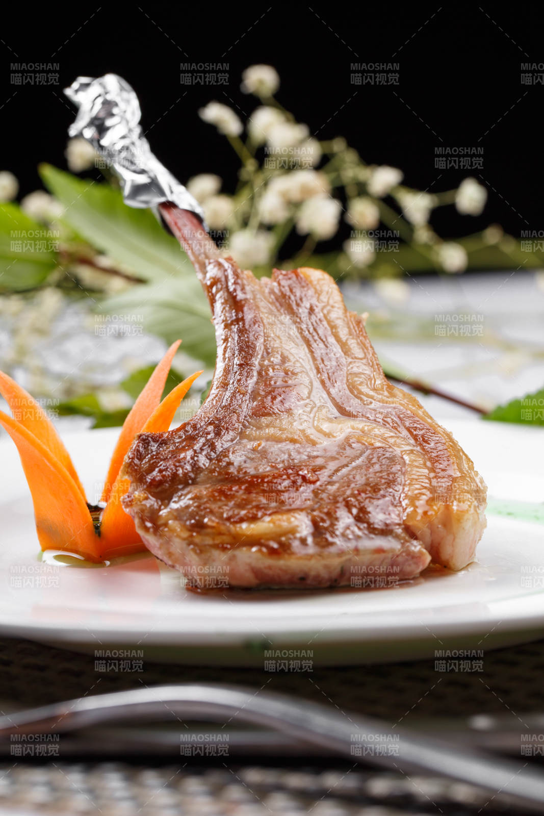 圆形白瓷盘装的波尔多法式铁板羊排摆放在餐垫上