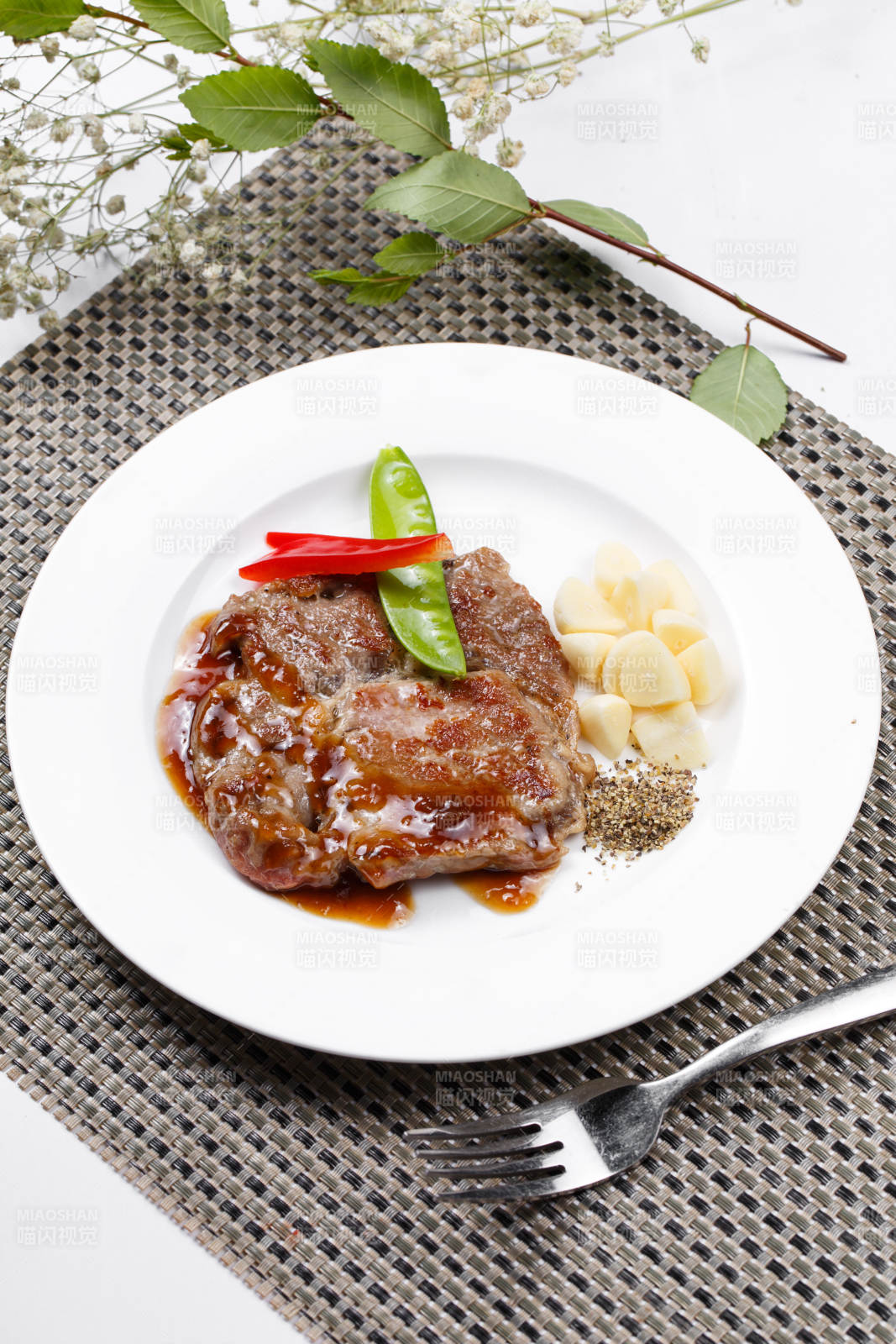 黑椒醬鐵板煎蒜香豬排擺放在餐墊上