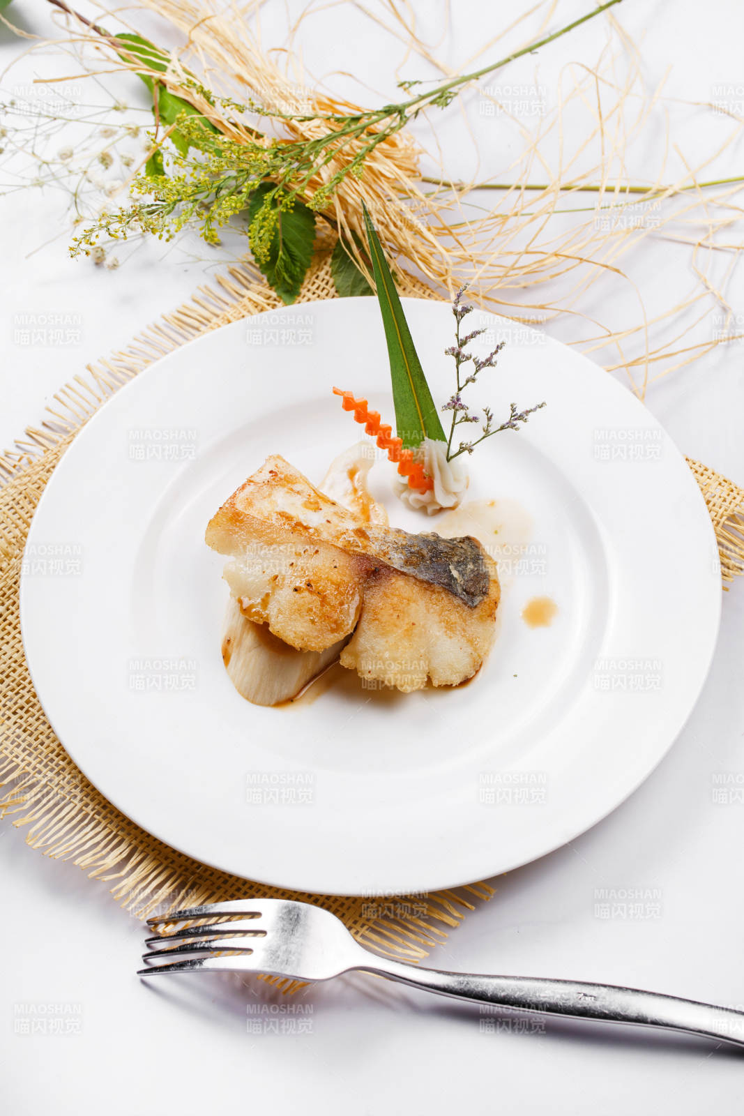 白色圓盤(pán)裝的俄羅斯深海龍鱈魚(yú)擺放在草墊上