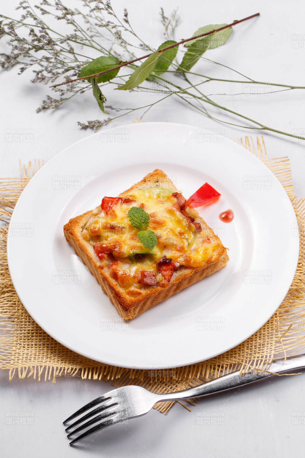 白色圓盤裝現烤海鮮牛肉小披薩擺放在草墊上