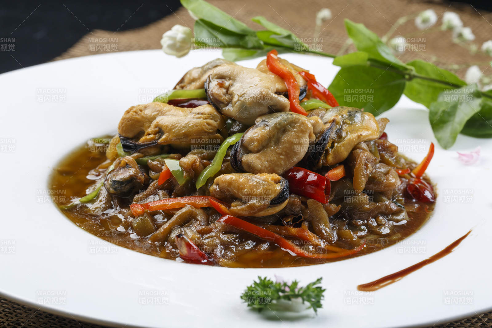 圆形磁盘装的酱爆生蚝-摄影图