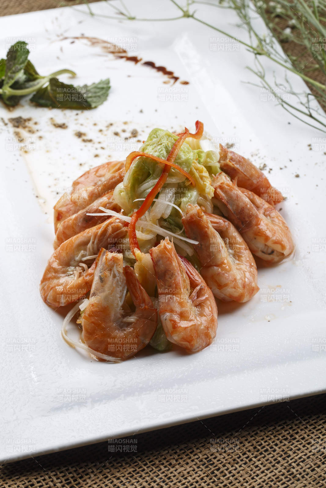 方形白瓷盘装的大明虾炒菜心图片