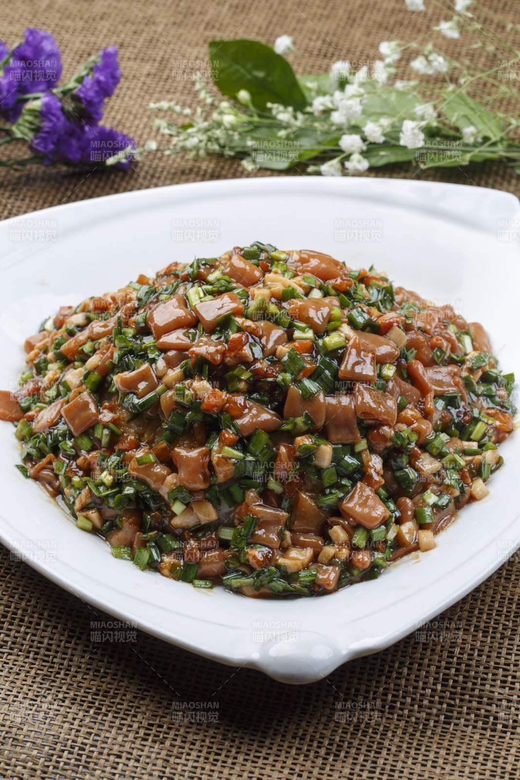 三角形白瓷盘装的海鲜韭菜炒海肠