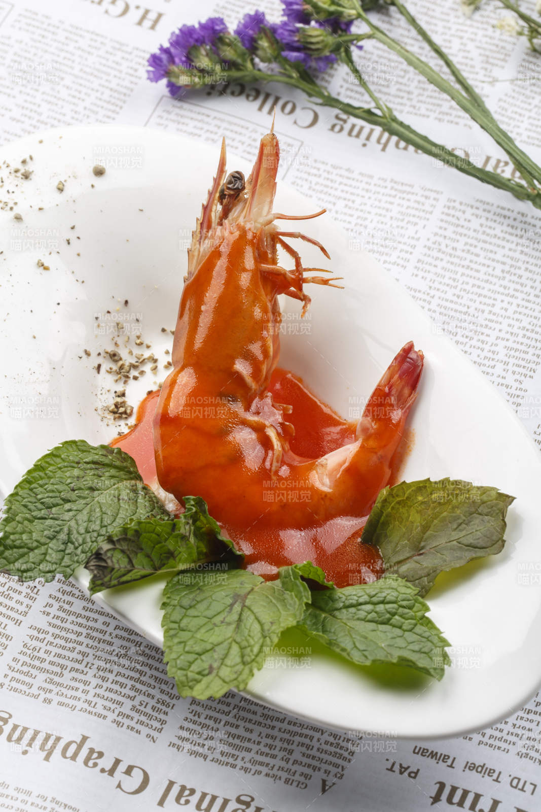 白色椭圆瓷盘装的浇汁大明虾