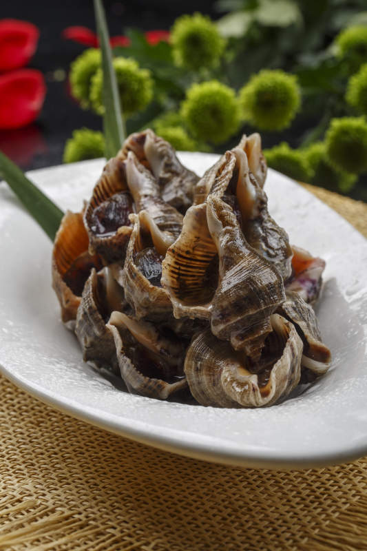 異形白瓷盤裝的海鮮醬爆小海螺