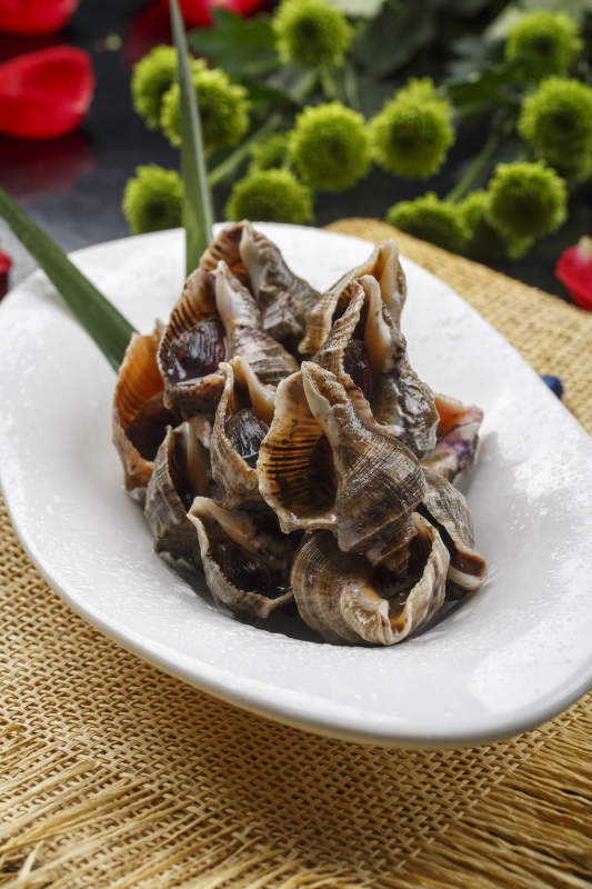 異形白瓷盤裝的海鮮醬爆小海螺