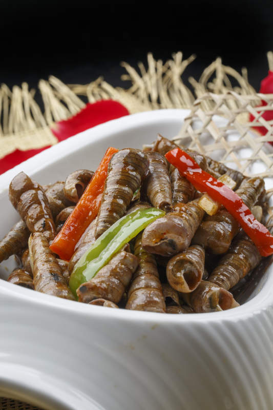 異形白瓷盤裝的海鮮辣炒珍螺釘子螺