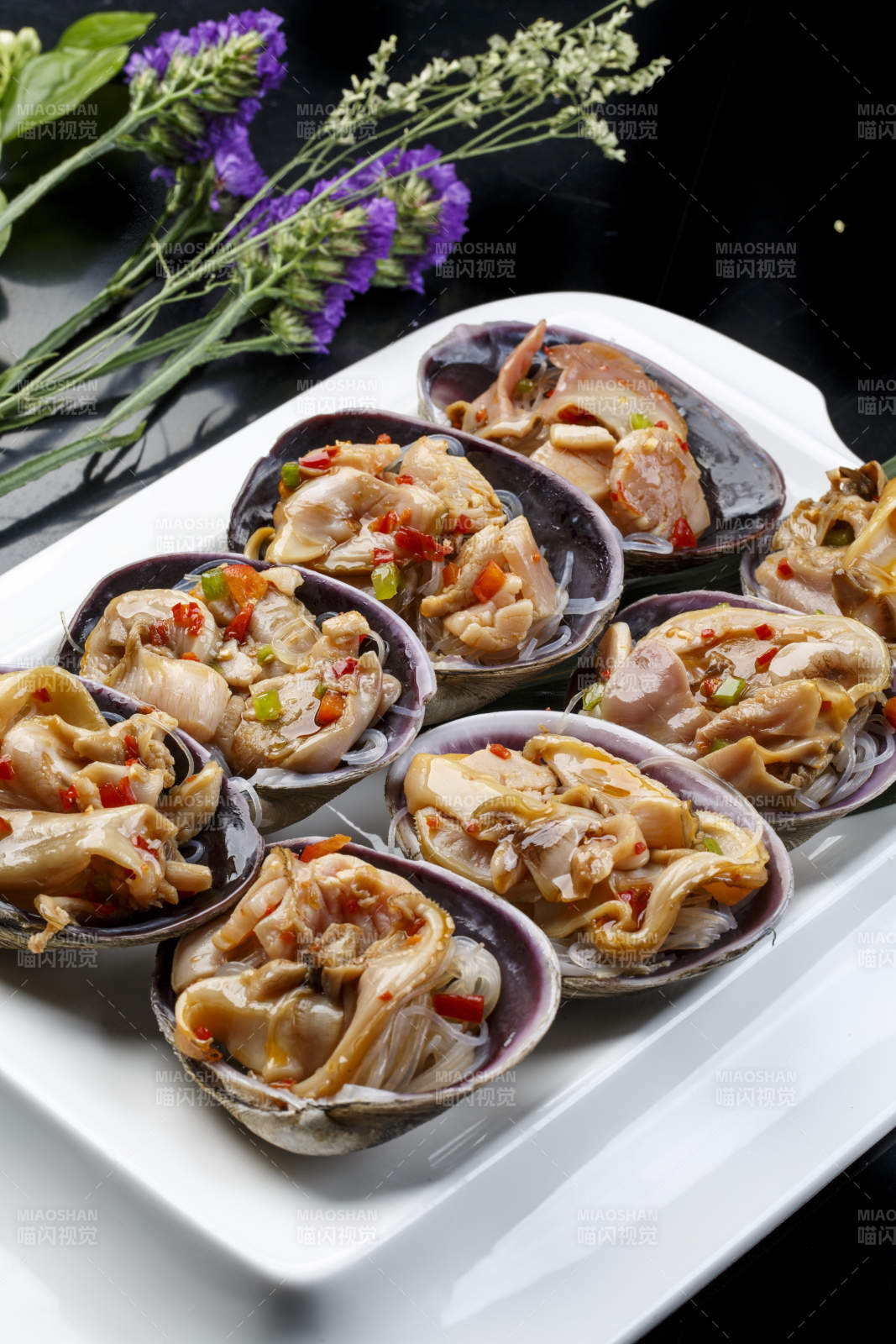 鼎形瓷盘装的海鲜炭烤紫石房蛤天鹅蛋