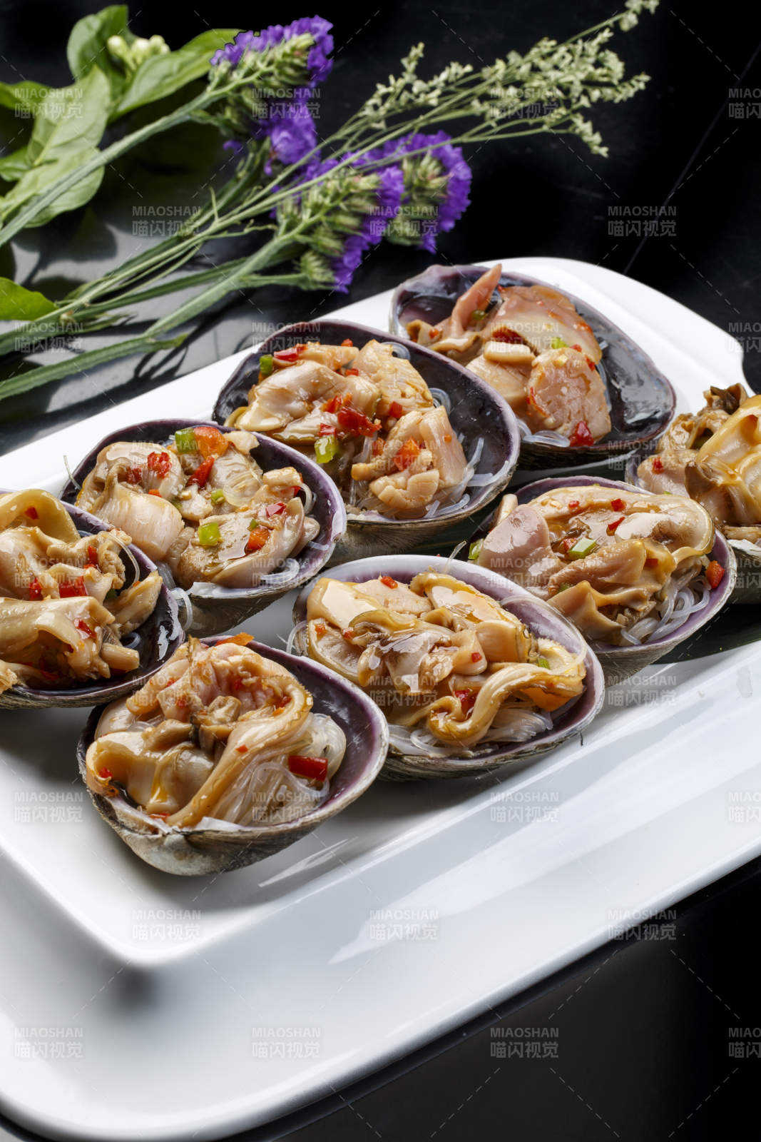 鼎形瓷盘装的海鲜炭烤紫石房蛤天鹅蛋