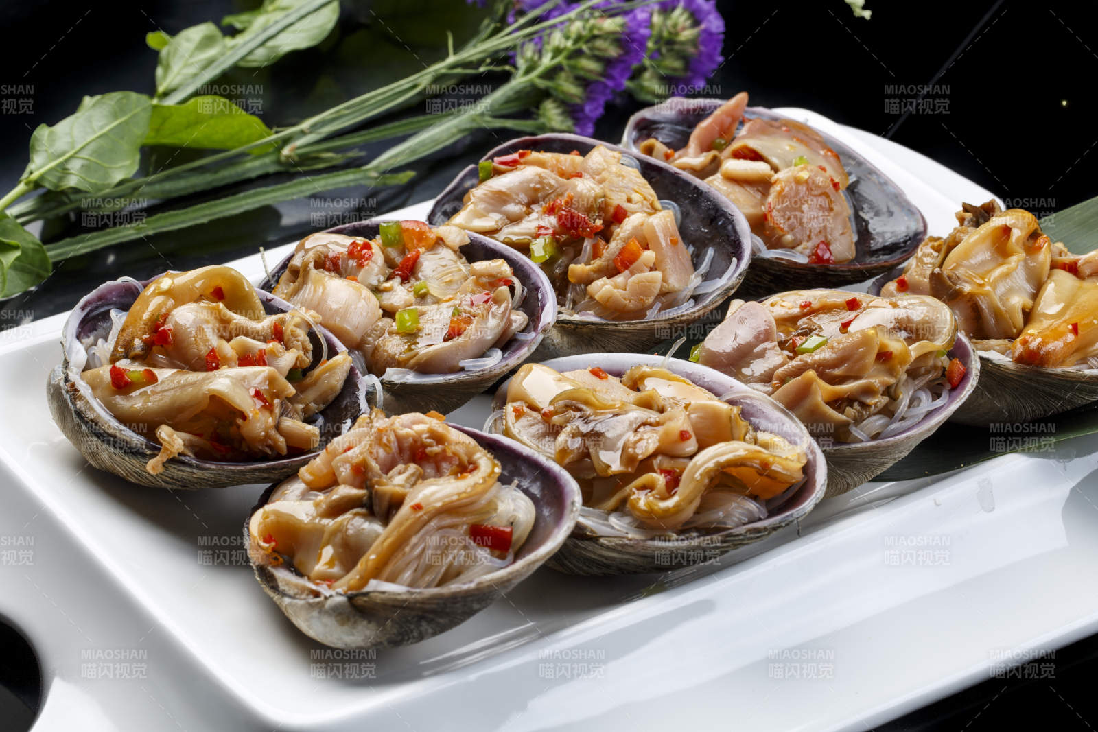 鼎形瓷盘装的海鲜炭烤紫石房蛤天鹅蛋