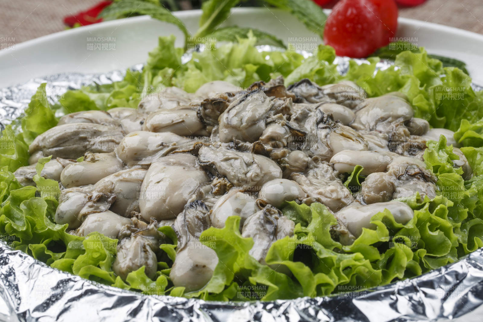 白色瓷盤裝的白灼生蠔青口貝