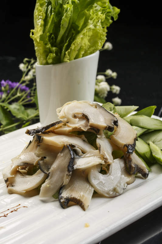 白色瓦楞形瓷盤裝的溫拌大海螺