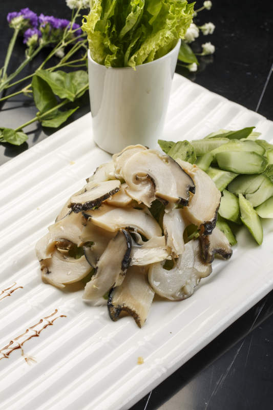 白色瓦楞形瓷盤裝的溫拌大海螺