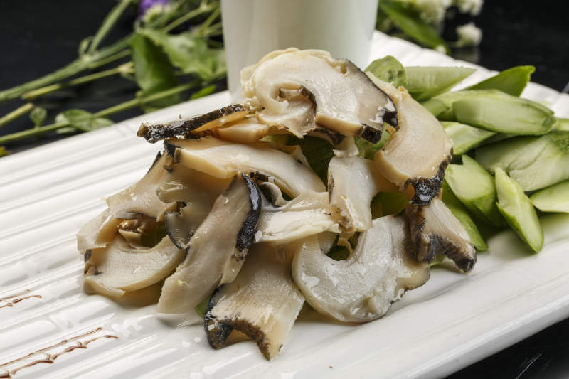 白色瓦楞形瓷盤裝的溫拌大海螺