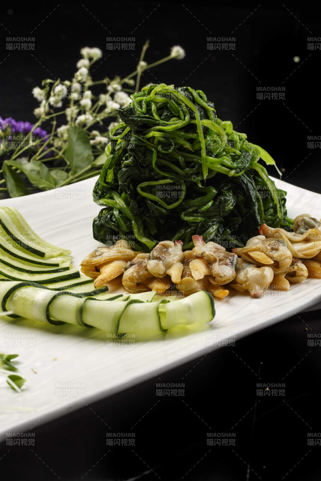 白色长方形瓷盘装的菠菜拌蛤肉