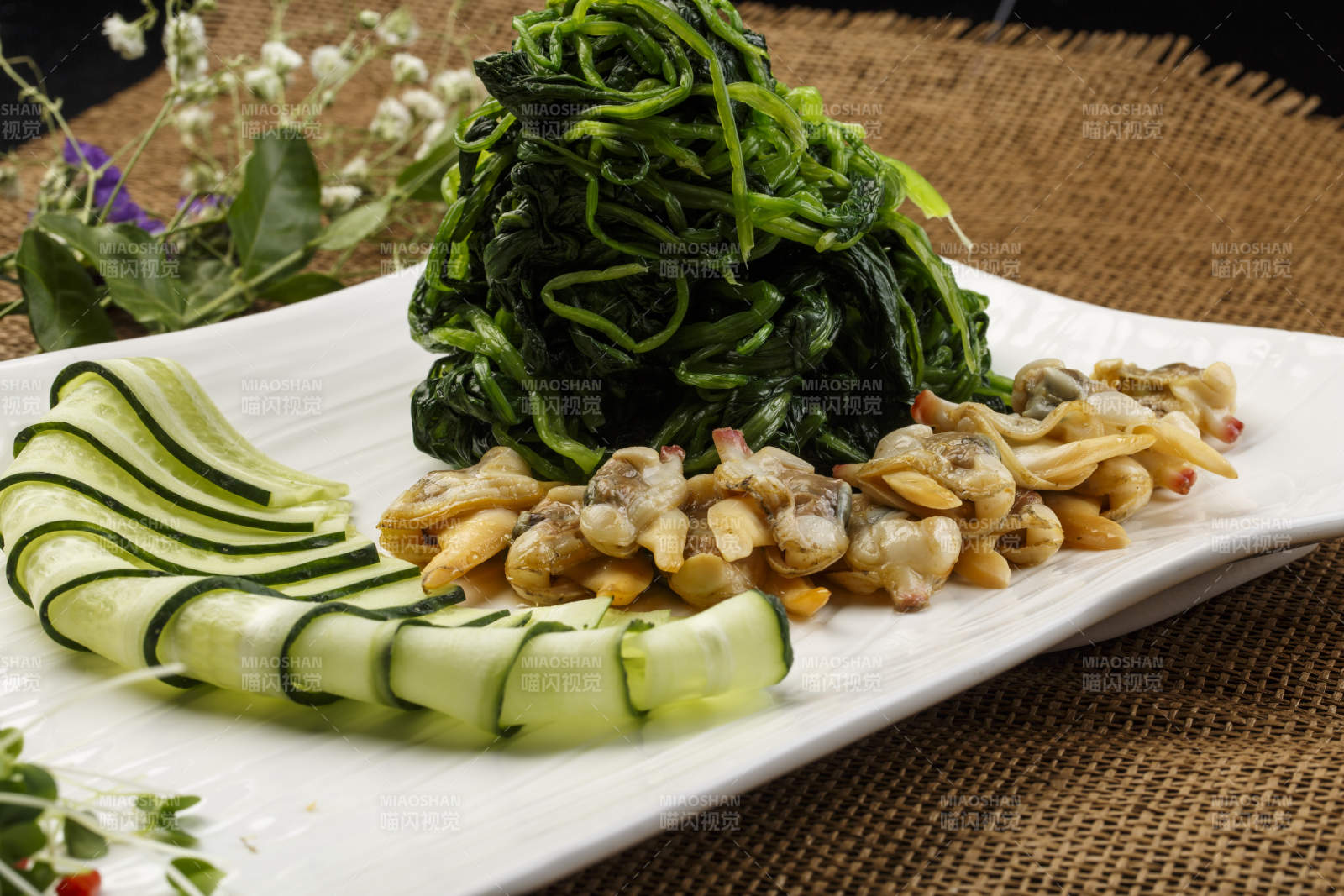 白色长方形瓷盘装的菠菜拌蛤肉