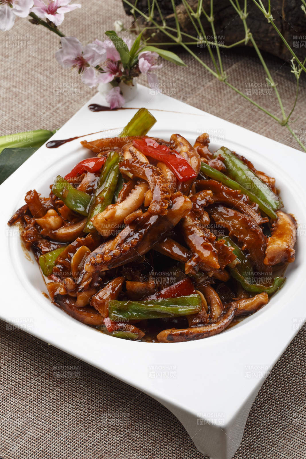 白色瓷盘装的的海鲜香辣酱爆鱿鱼须