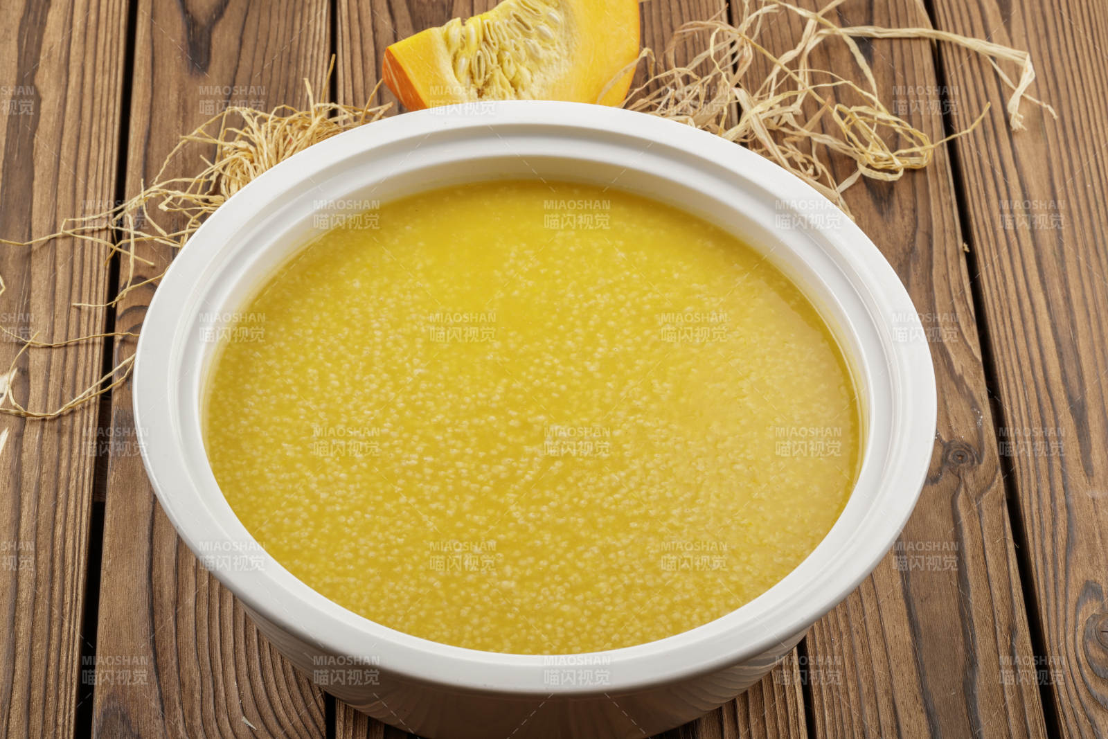 白色汤盆装的金瓜小米粥