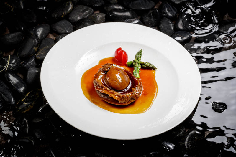 白色瓷盘装的浇汁南非干鲍