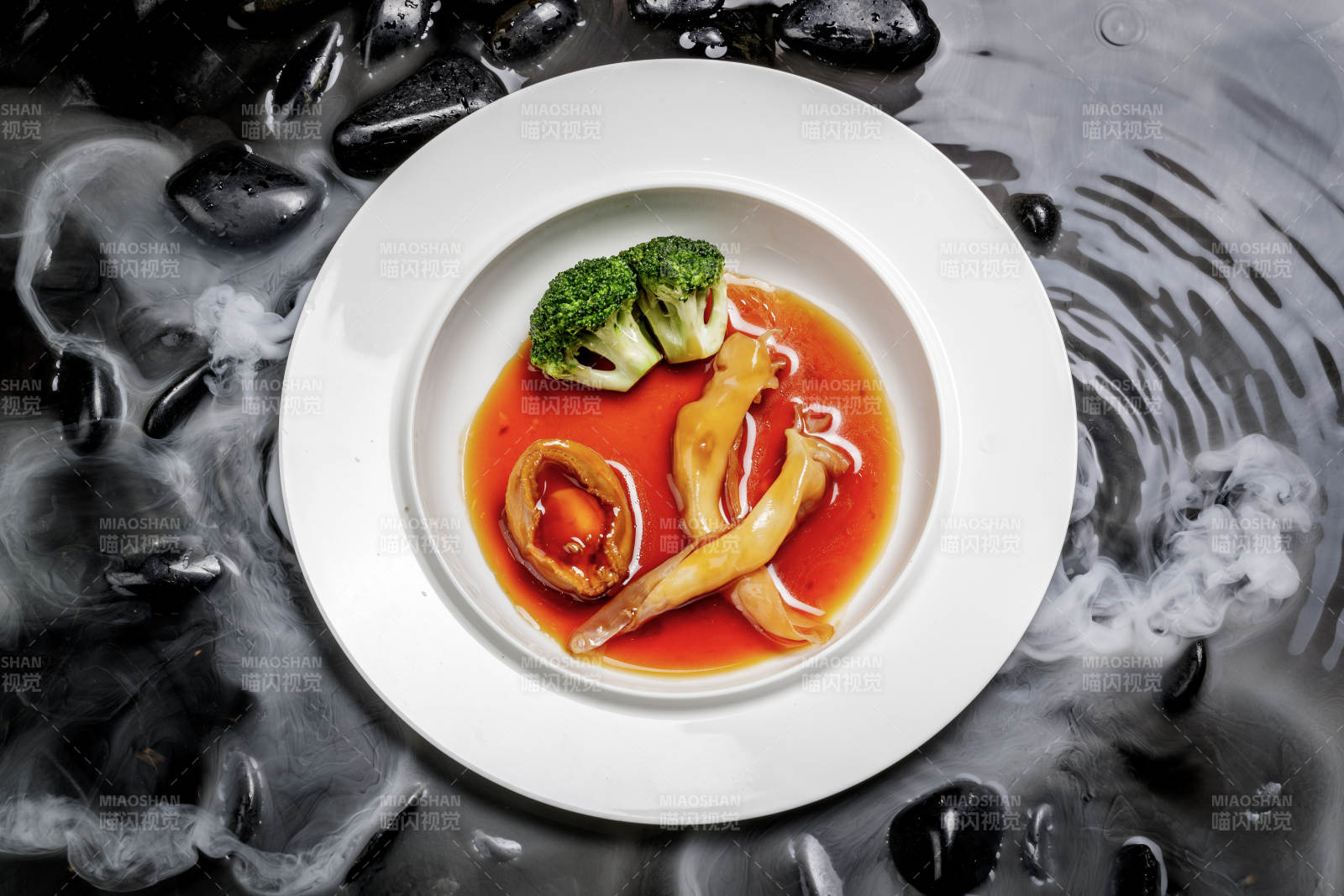 鲍汁鲍鱼烩花胶摆放在干冰缭绕的水中