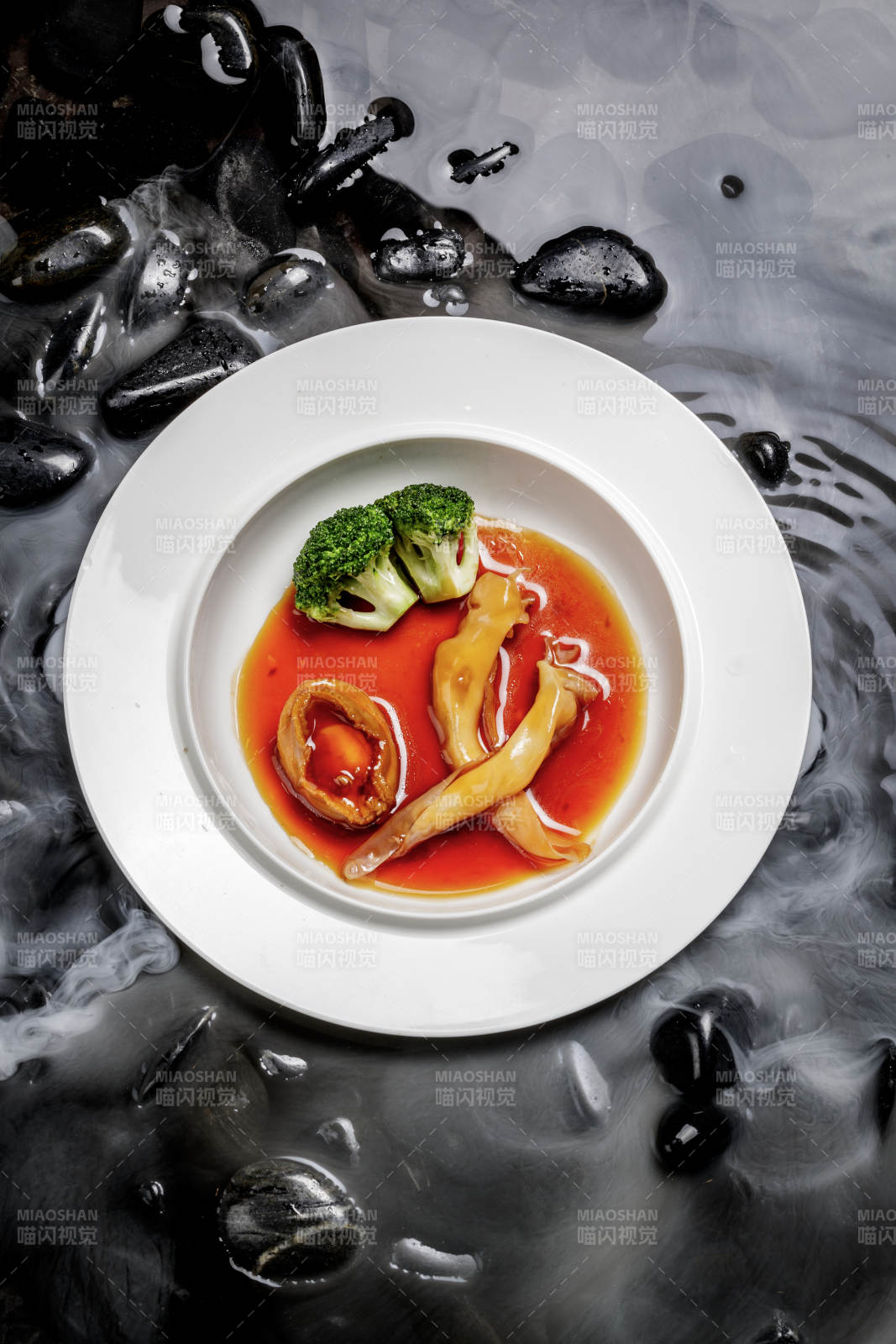 鲍汁鲍鱼烩花胶摆放在干冰缭绕的水中