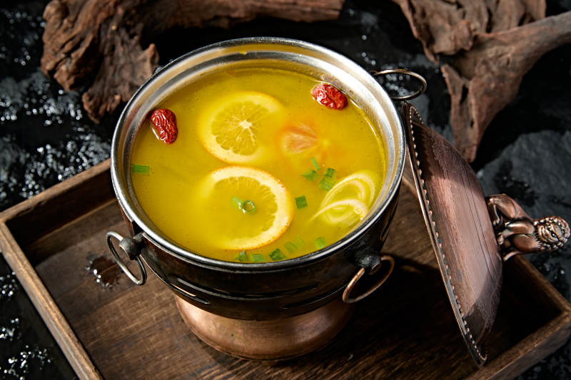 精致小火锅装的橙味鸡汤锅底