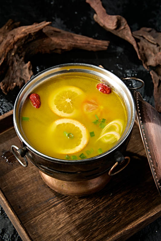 精致小火锅装的橙味鸡汤锅底