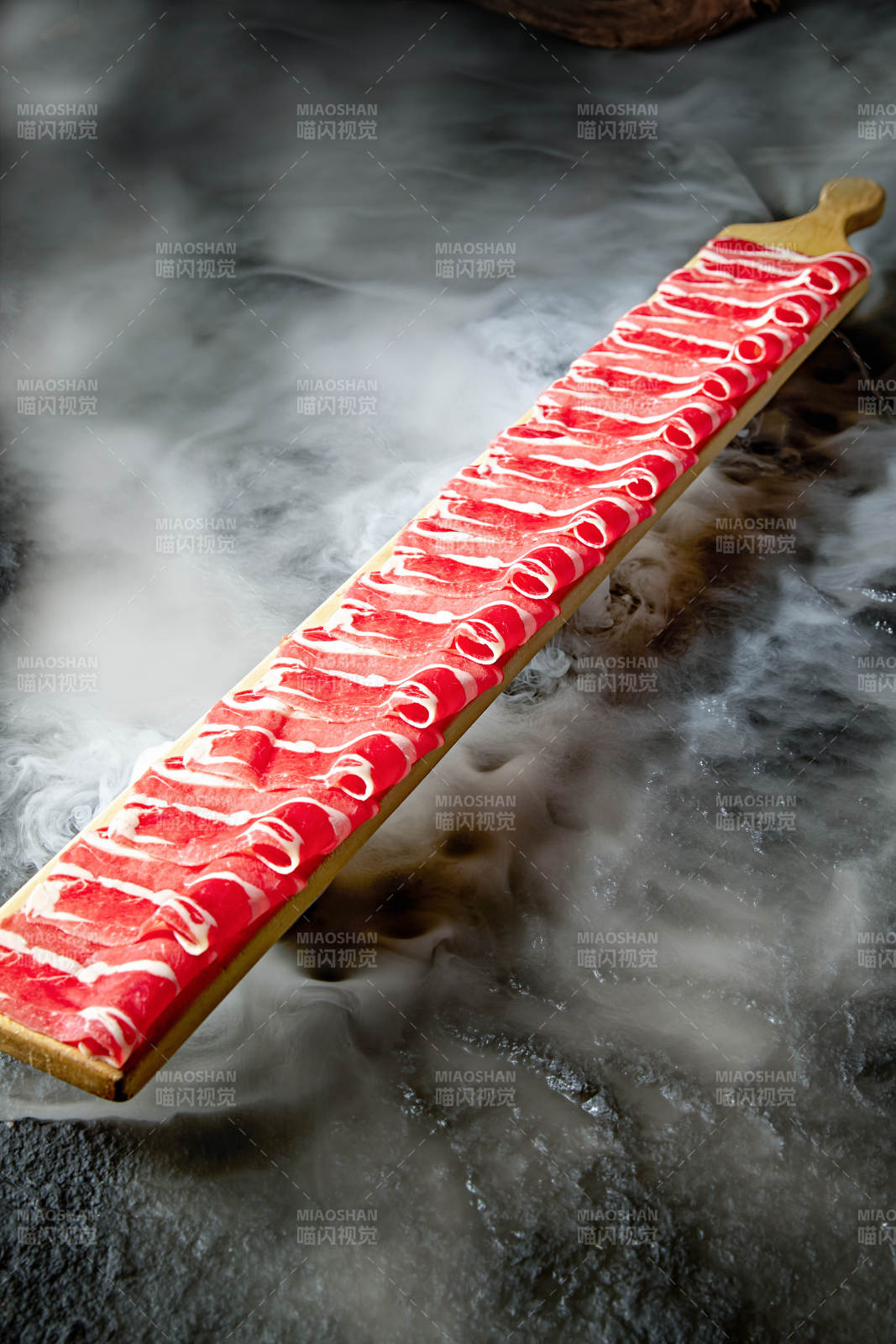 干冰缭绕的背景上摆放的和牛一米肉片-摄影图