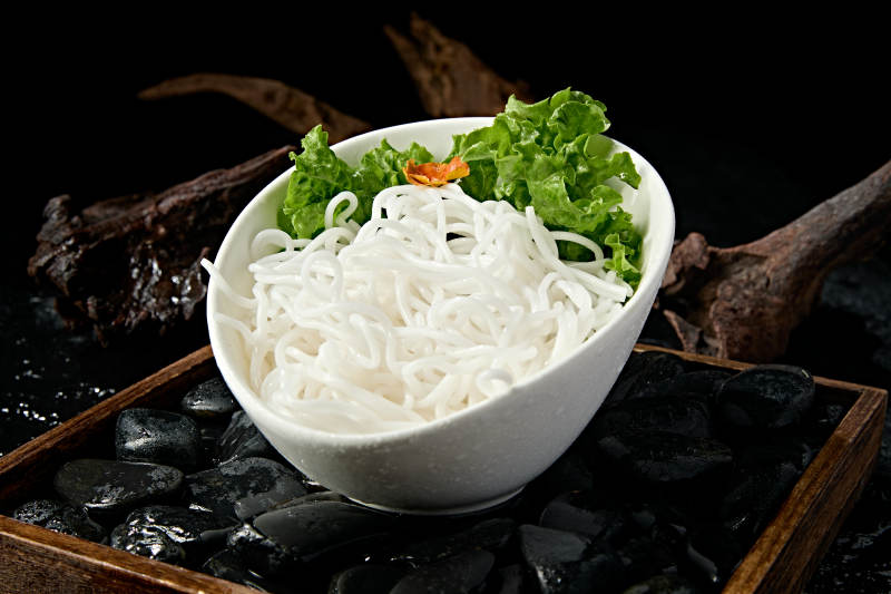 青色瓷盘装的火锅食材土豆粉条