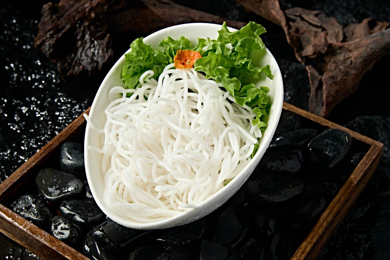 青色瓷盘装的火锅食材土豆粉条