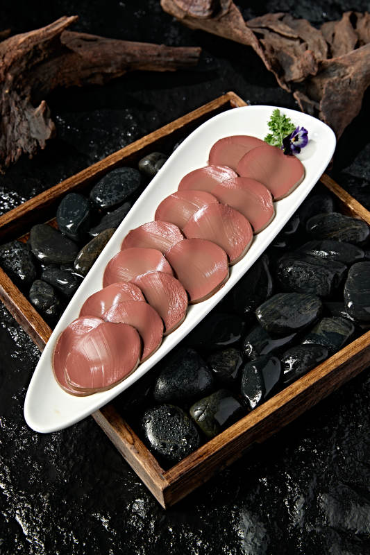 白色瓷盘装的火锅食材鸭血切片