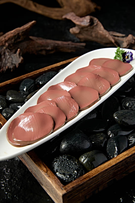 白色瓷盘装的火锅食材鸭血切片