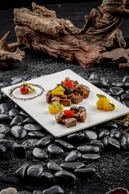 黑蒜牛小排摆放在黑色鹅卵石上