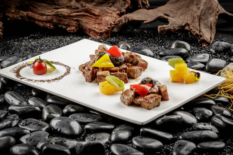 黑蒜牛小排摆放在黑色鹅卵石上