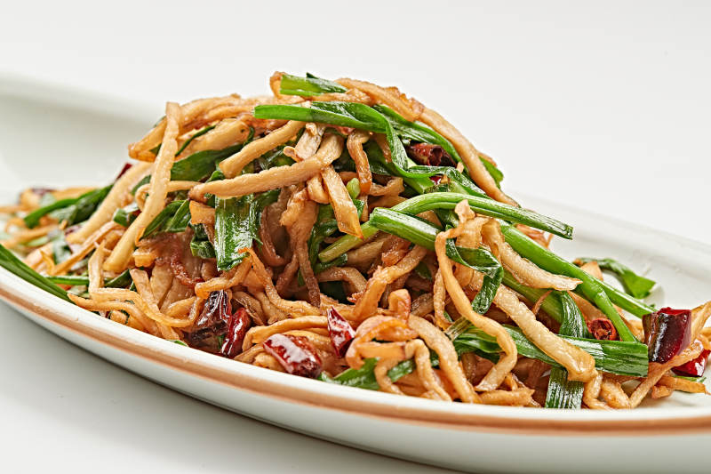 白色瓷盘装的韭菜辣炒杏鲍菇