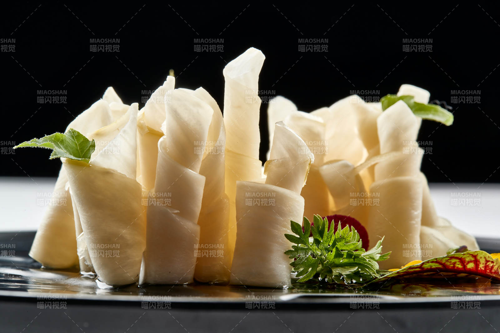 黑色瓷餐具装的鲜杏鲍菇刺身卷