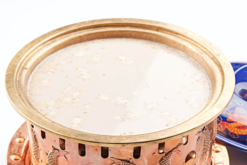 傳統(tǒng)銅鍋餐具裝的蒙族炒米燉奶茶