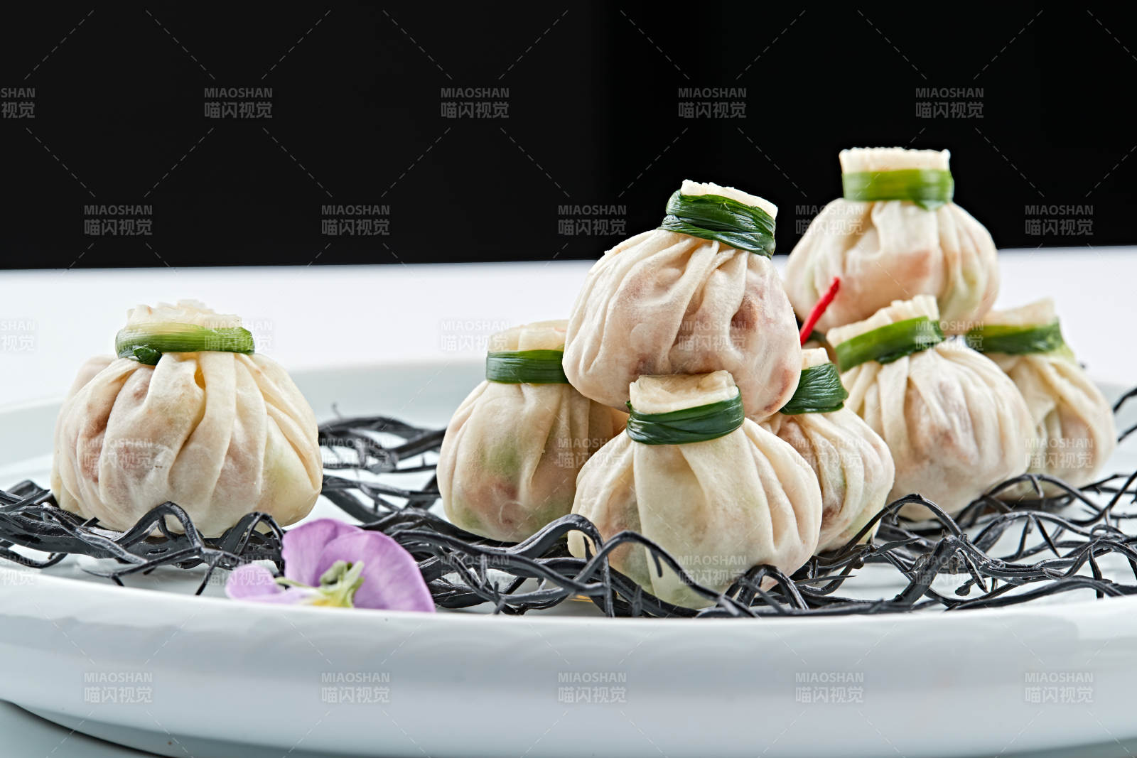 青色瓷盘装的精美蒸小福袋