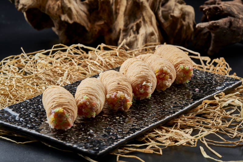 黑色瓷盤裝的香酥奶黃蛋酥