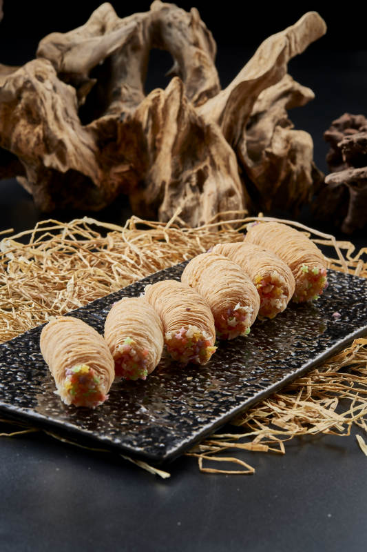 黑色瓷盤裝的香酥奶黃蛋酥