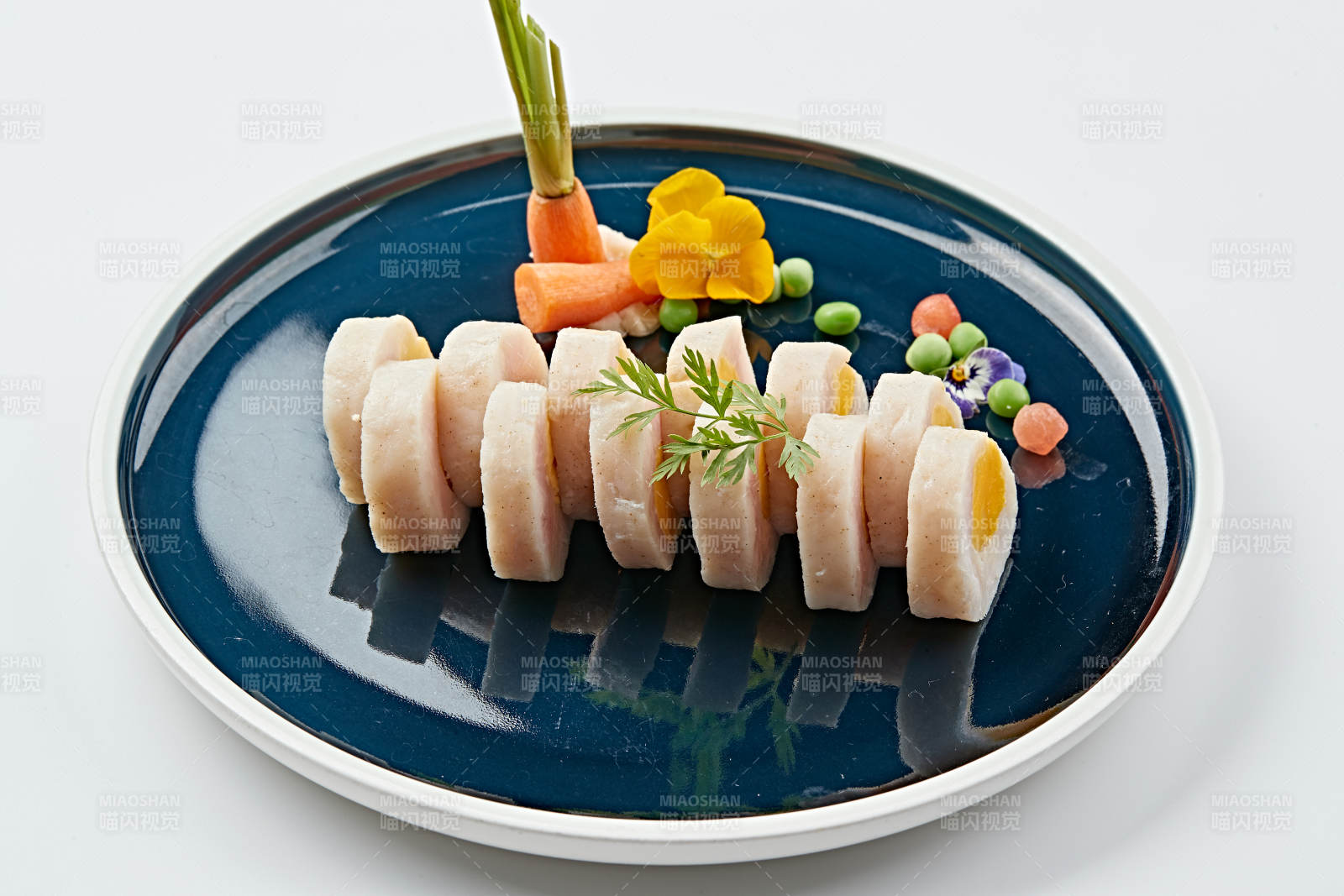 蓝釉瓷盘装的墨鱼泥压咸蛋黄切片