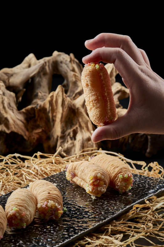 黑色瓷盤裝的香酥奶黃蛋酥