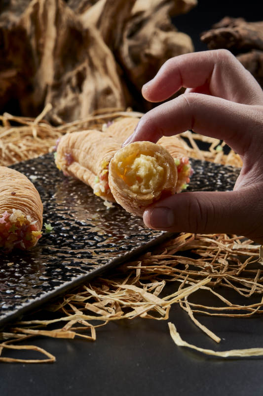 黑色瓷盤裝的香酥奶黃蛋酥